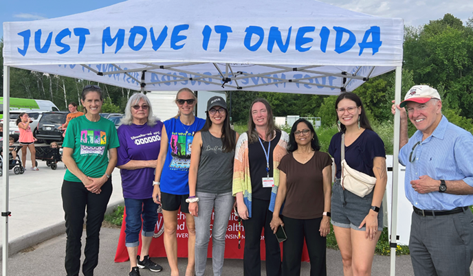 NACHP team smiling under “Just Move It Oneida” canopy