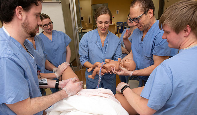 Wisconsin Academy of Rural Medicine MD students practice delivering babies in a clinical simulation lab