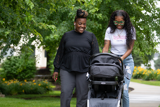 Kim Ashford and TyiKalia Johnson walking outside with a stroller