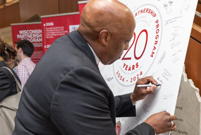 A man signs a board with his name