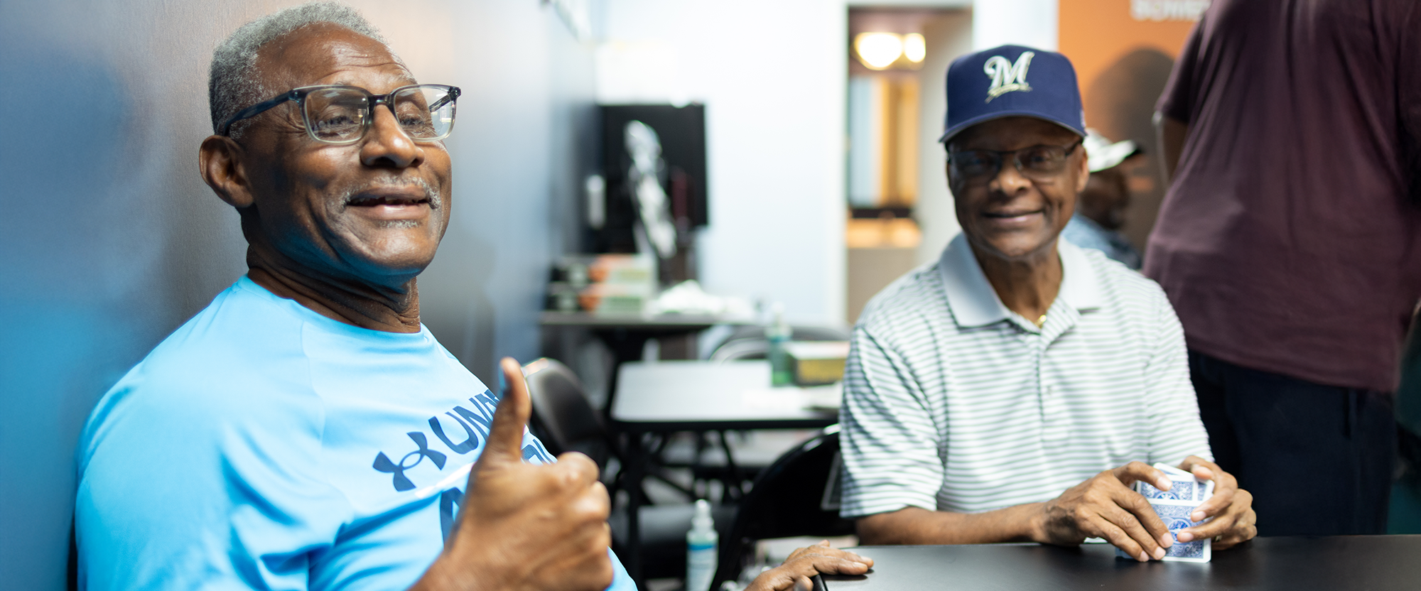 Two men smile while playing cards