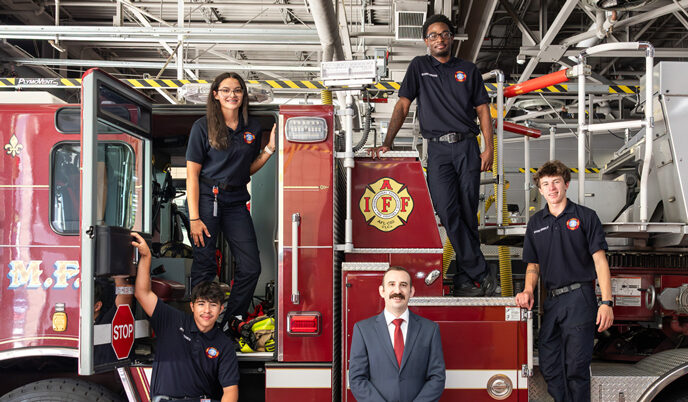 Five people standing on a fire truck