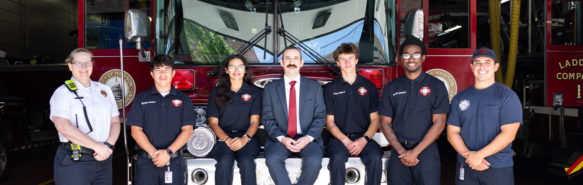 Fire service student interns standing on a fire truck