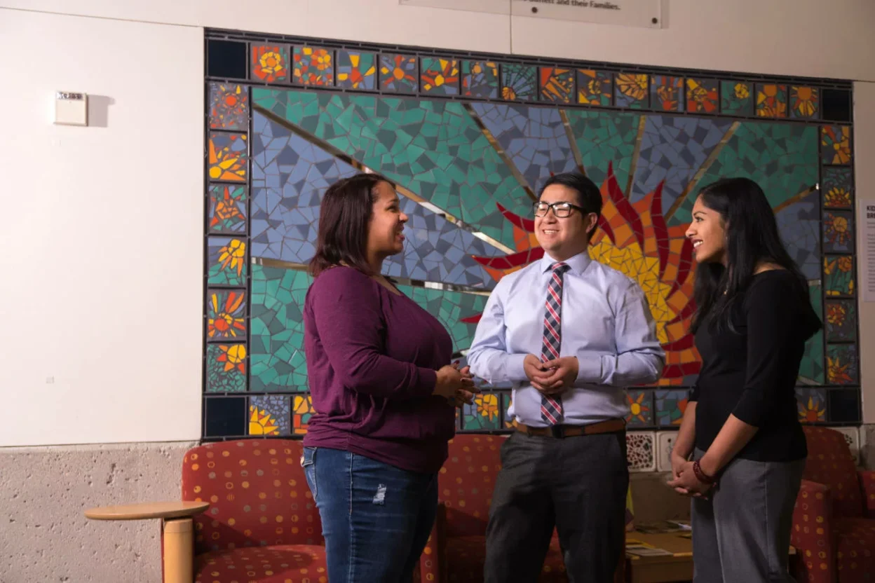 Three people meeting at the Lussier Community Education Center