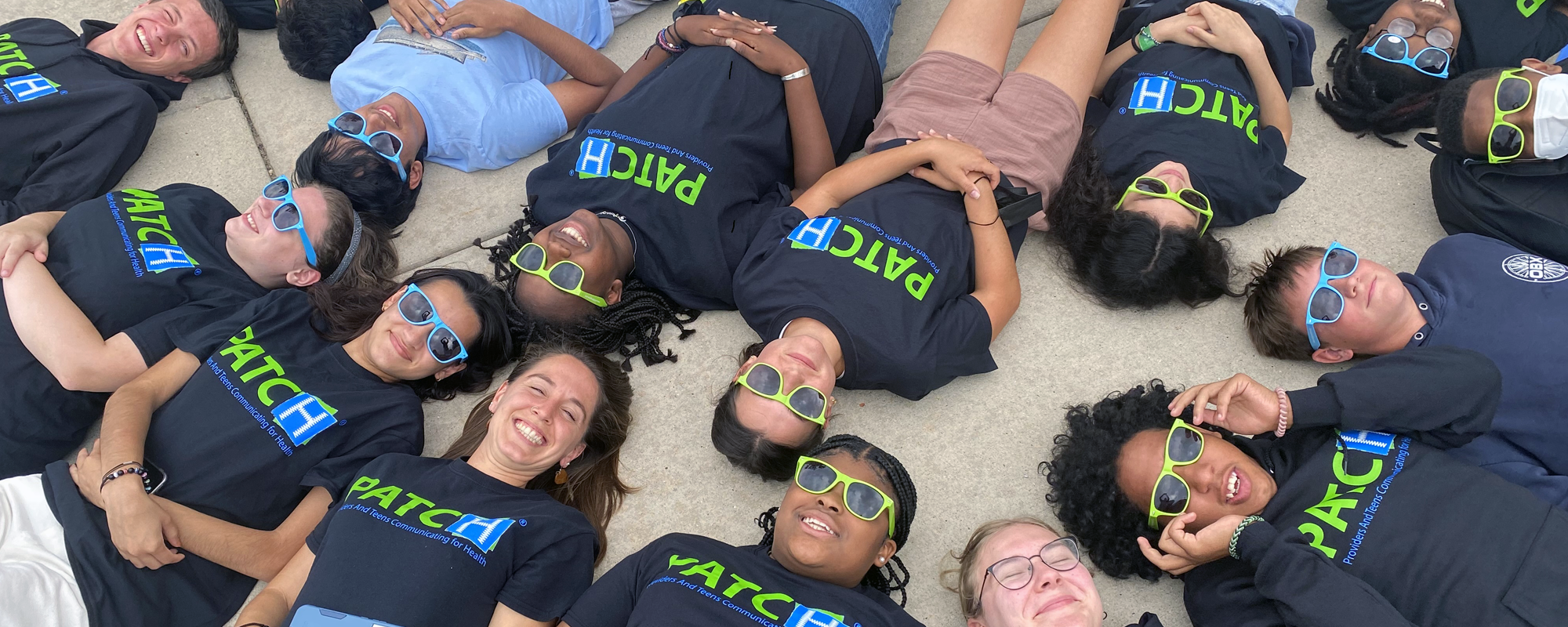 PATCH teams laying on the ground with heads together