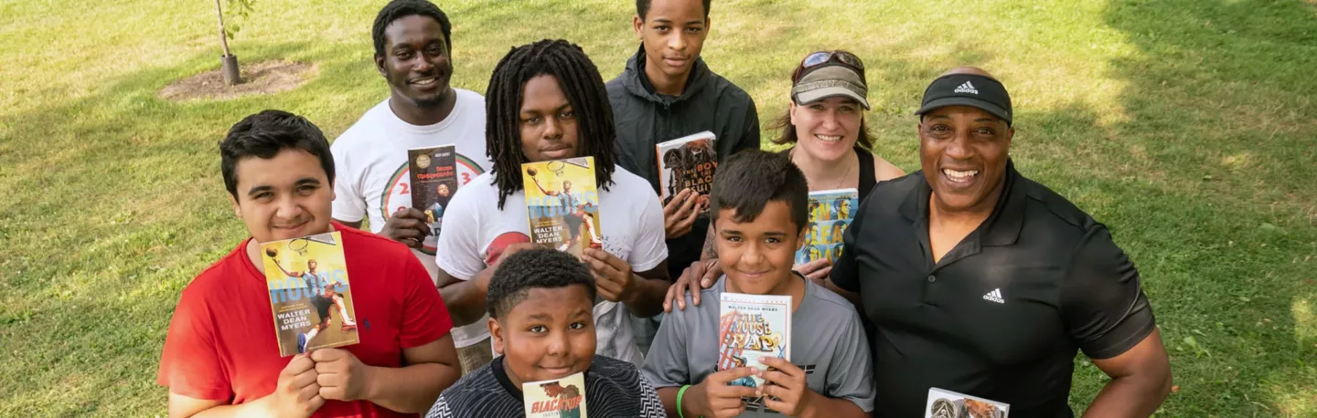 Adults and kids show off the books they are reading