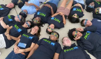 PATCH teams laying on the ground with heads together