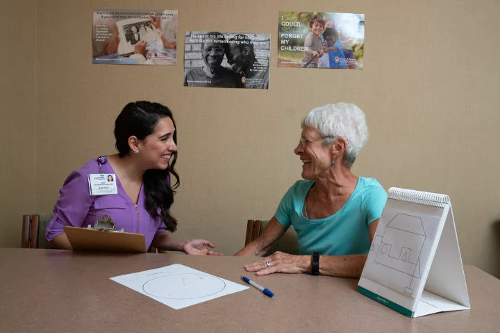 A research participant enjoys completing a memory exam with a research specialist